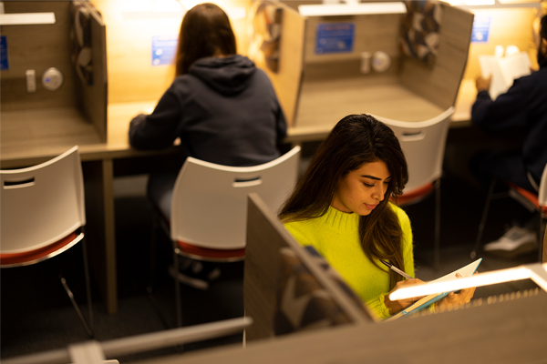 A student sat in the library reading a book