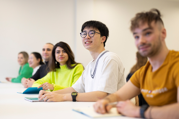 Students sat in a row looking off camera