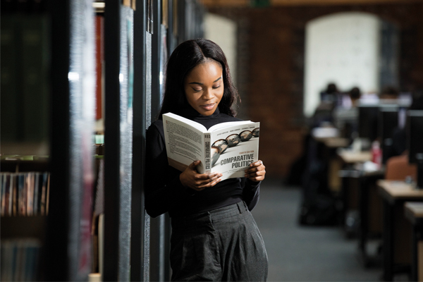 A student stood in a library reading