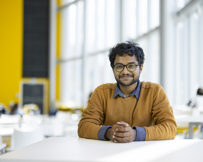 A student sitting in the Isaac Newton Building