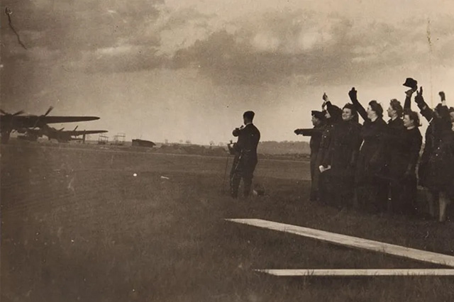 An archive photo of RAF ground crew waving off Lancaster aircraft