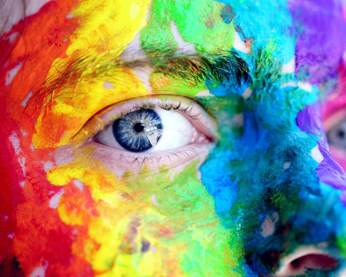 A person wearing rainbow face paint