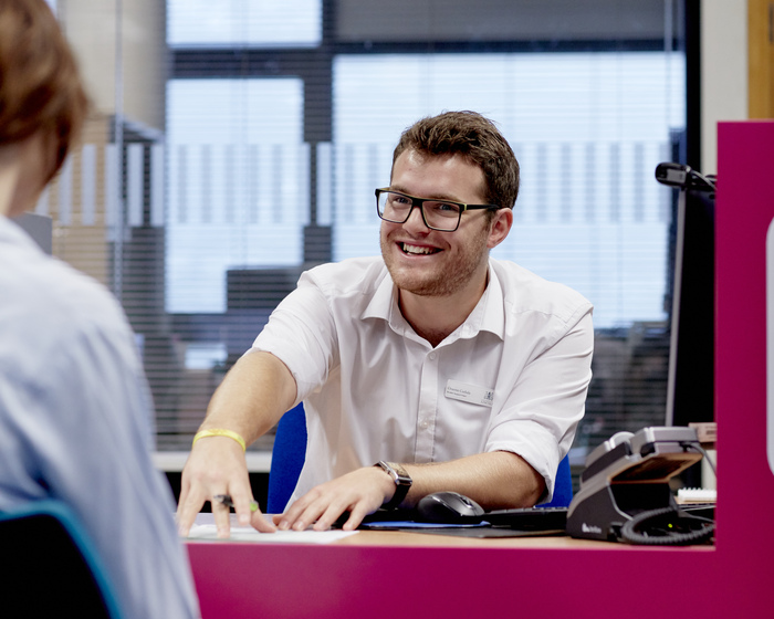 A student support staff member speaking to a student