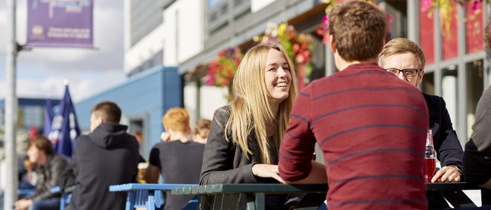 Students sitting at tables outside the Swan