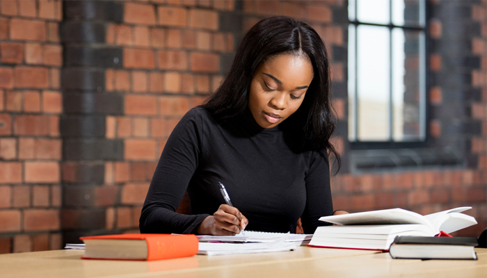 A student writing in the library