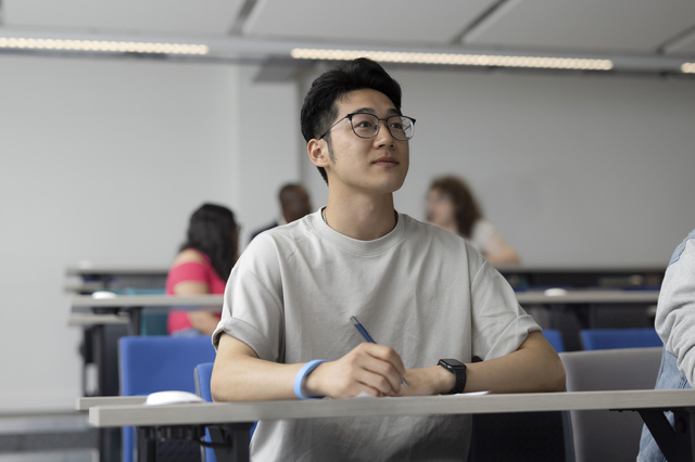 A student taking notes in a seminar