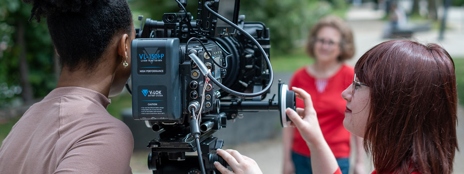 A group of students filming using a large digital camera