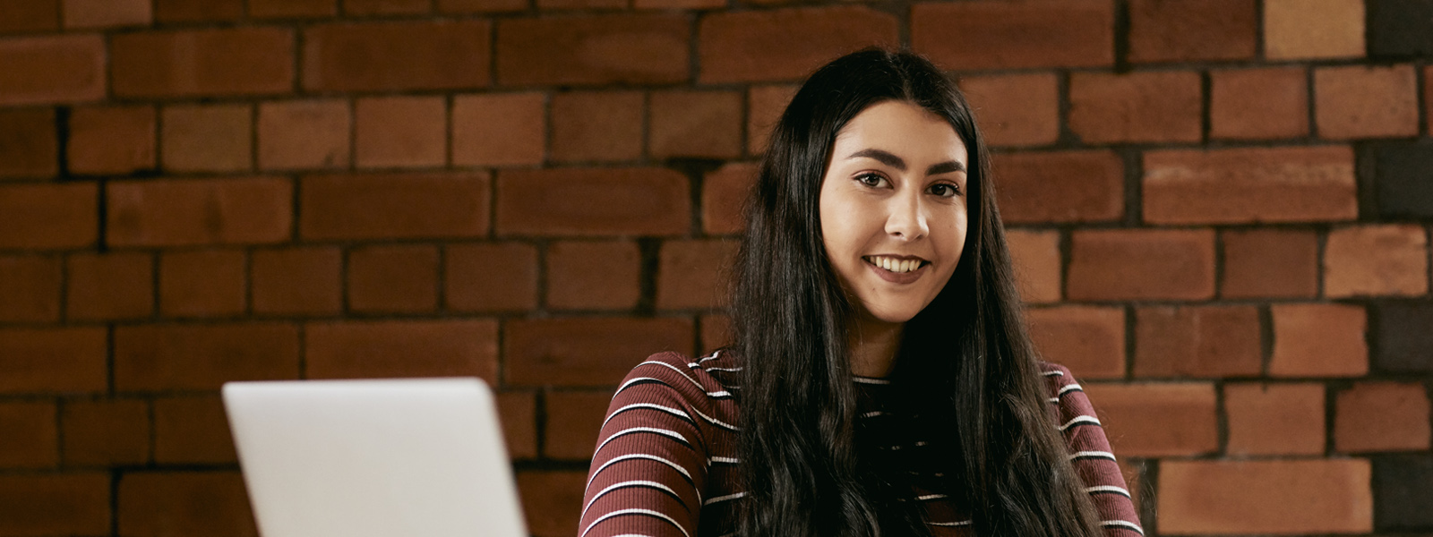 Female student with a laptop in the library