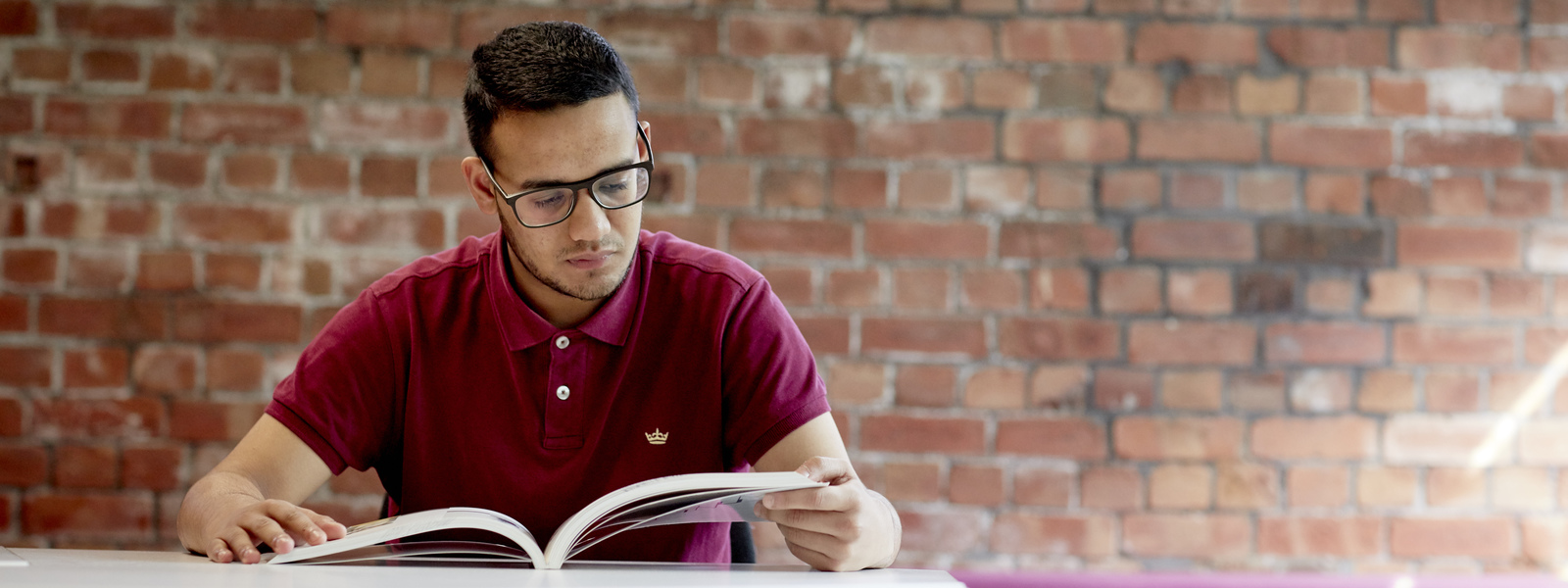 Student reading a textbook in the library