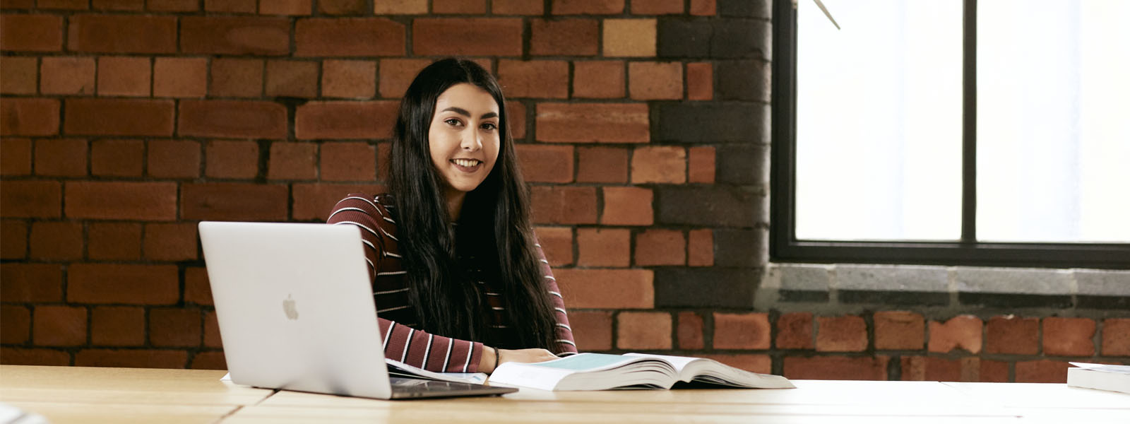 Female student with a laptop in the library