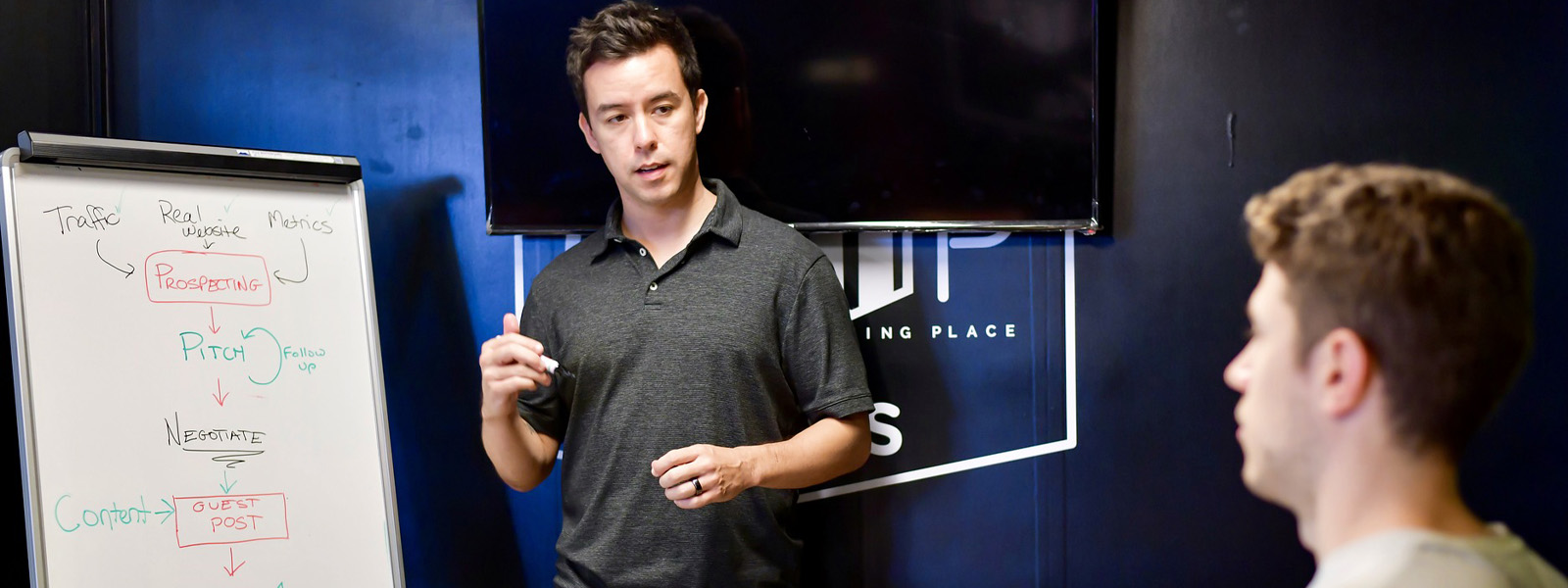 A man stood at a flip chart discussing a project