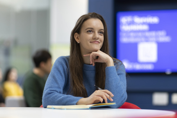 A student writing in a seminar room