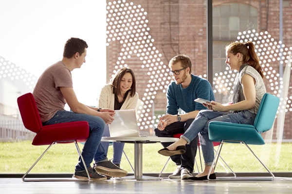 A group of students sat around a table, working together on a project