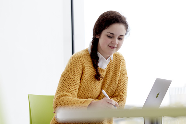 A student writing at a desk