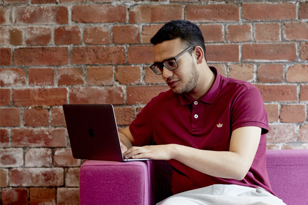 A student sat working on a laptop in the library