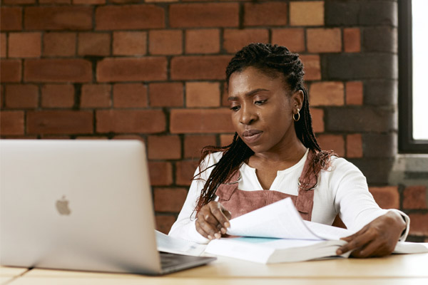 A student sat at a desk working on a laptop