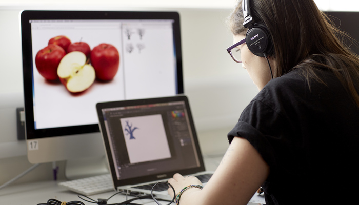 A student undertaking graphic design on a laptop