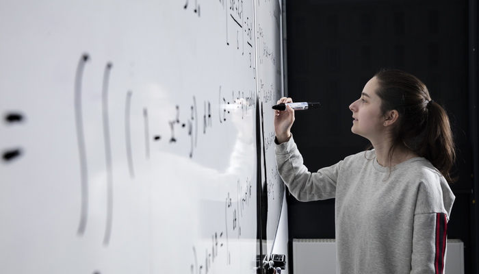 A student writing on a white board