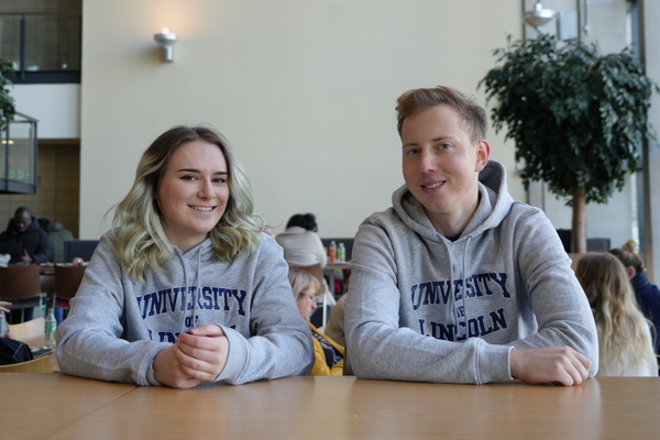 Two students wearing University of Lincoln hoodies