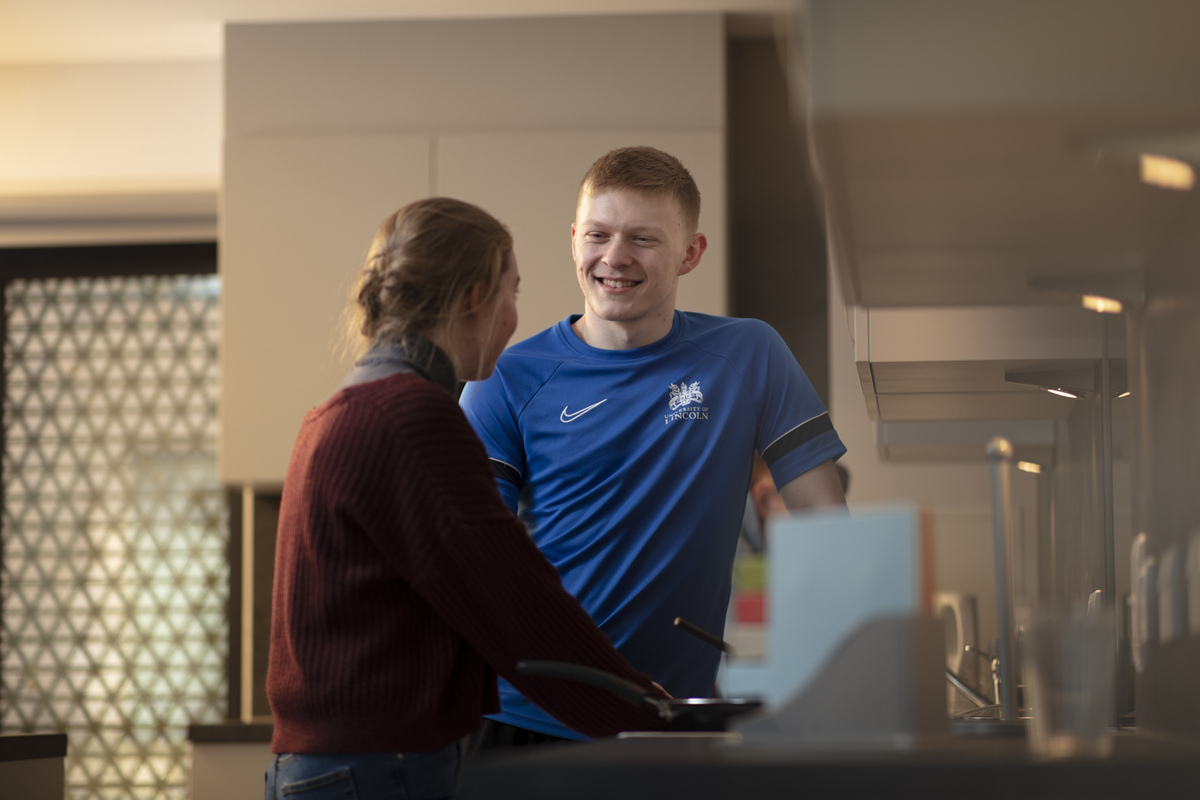 Students chatting while cooking in their kitchen