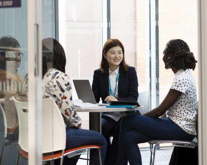 Seated students speaking to staff for assistance