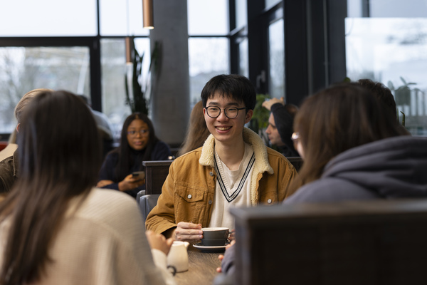 A student chatting with friend in a cafe