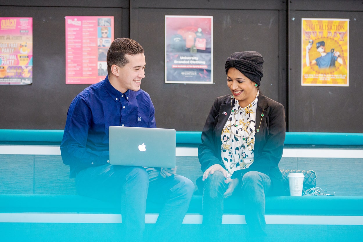 two students with a laptop