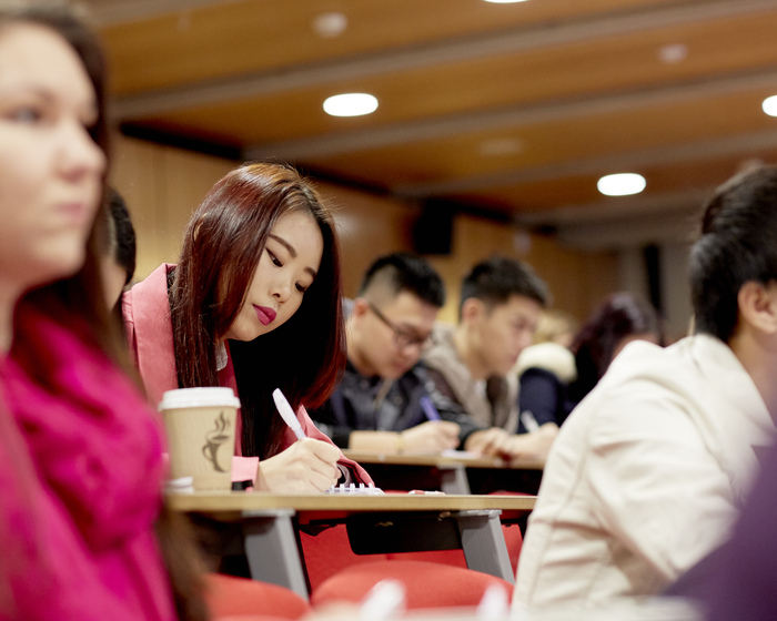 A student in a lecture taking notes