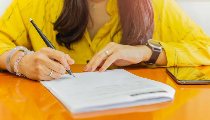 A person filling out a form.