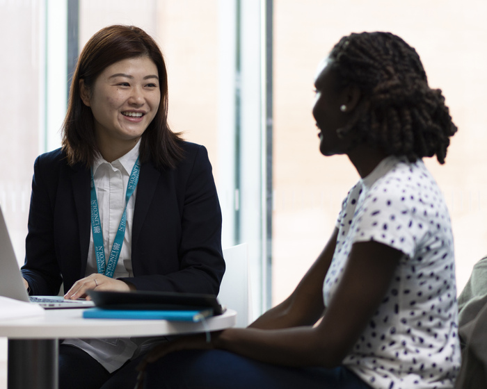 Two students talking at a table