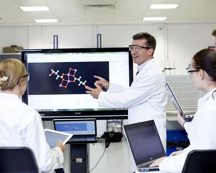 A lecturer presenting to students in a science lab