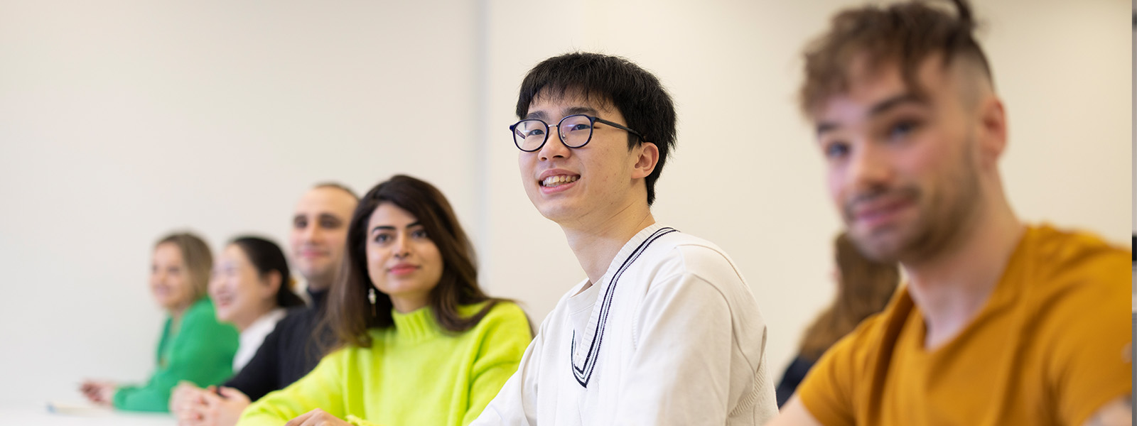 Students sat in a row listening to someone