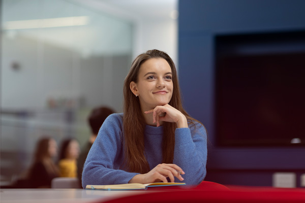 A female student sat at a table looking off camera