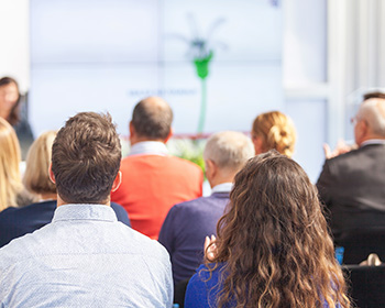 People sitting at a conference listening to a speaker