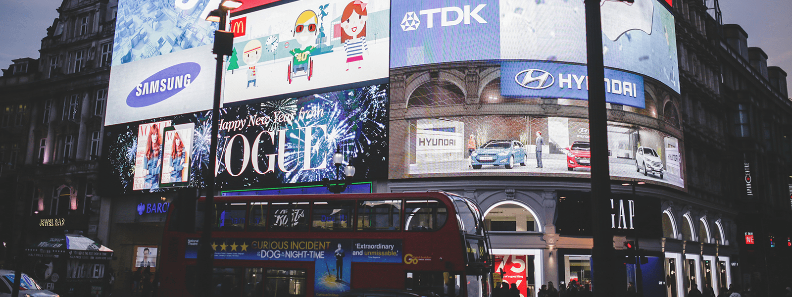 A city scene with advertising screens and buss ads