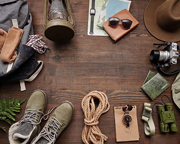 Collection of outdoor adventure items arranged in a circle on a wooden floor