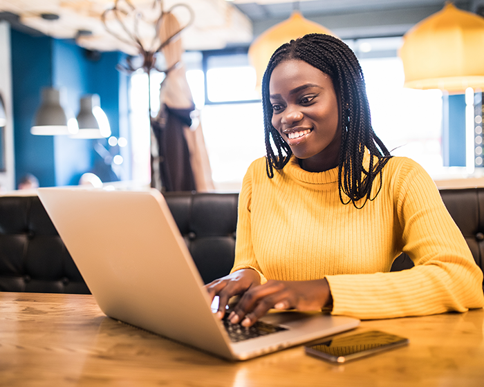 Woman dressed smart-casual working on laptop