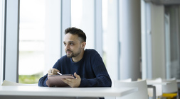 Student sitting at a table, thinking