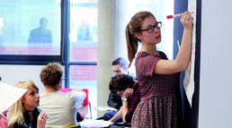 image of student writing on a board