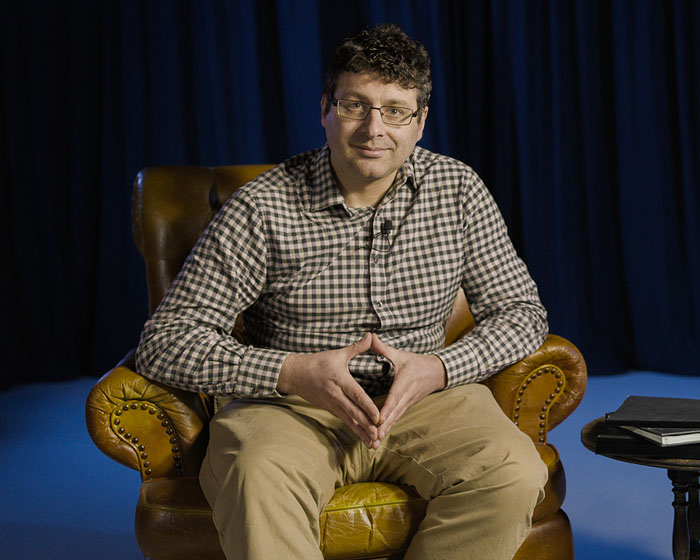 Charles Fox sat in an armchair smiling