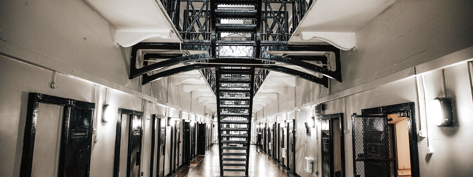 Inside a prison with cell doors and stairs