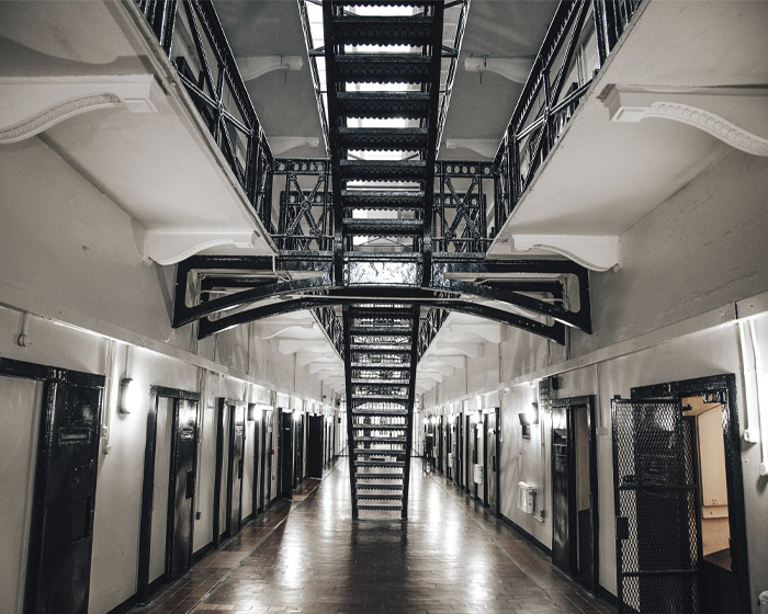 Inside a prison with cell doors and stairs