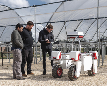 A group of students with a farming robot