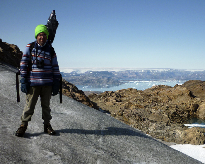 A man standing overlooking a glacier in Greenland