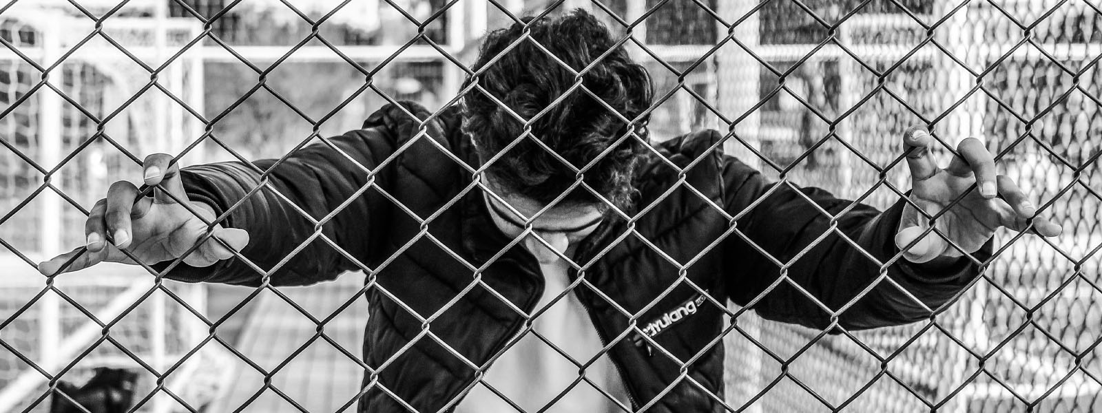 Somebody holding on to a fence
