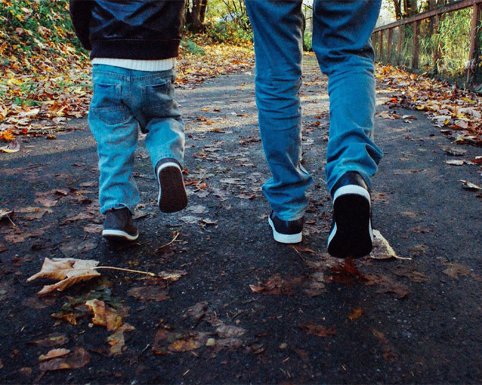 A man and child walking along a wooded path