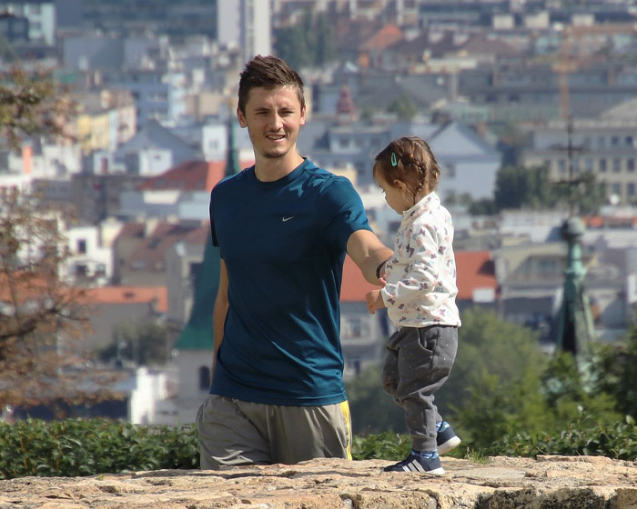 A man walking with his child on a city wall