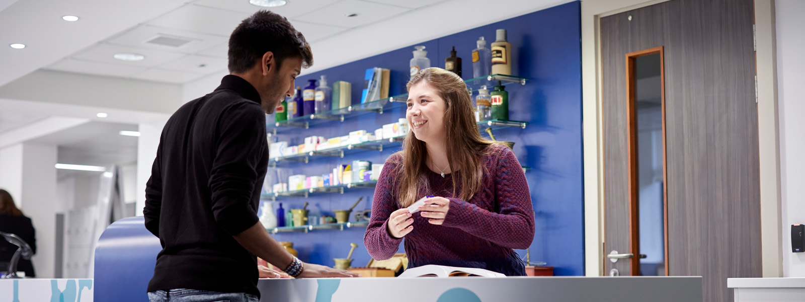 A customer talking to a pharmacist in a pharmacy