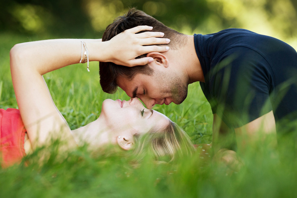 A couple laying together in a field of grass