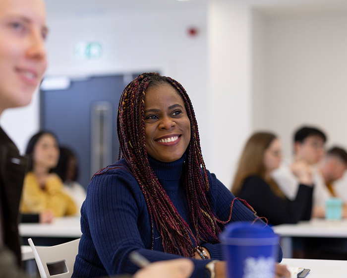 A student sat in a classroom smiling